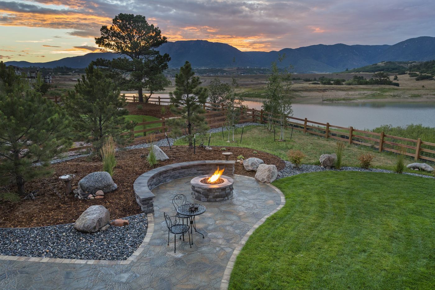 A fire-pit patio with a curved stone seat wall overlooking the Colorado Front Range.